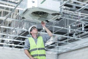 Commercial AC repair technician servicing unit.